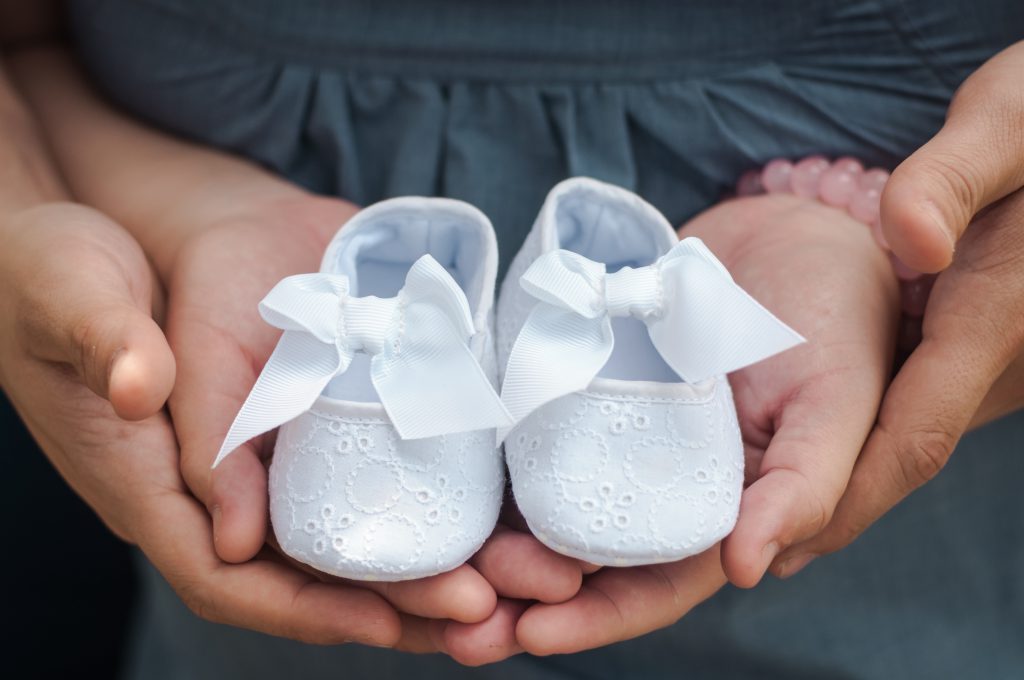 Des chaussures de bébé blanche avec un noeud