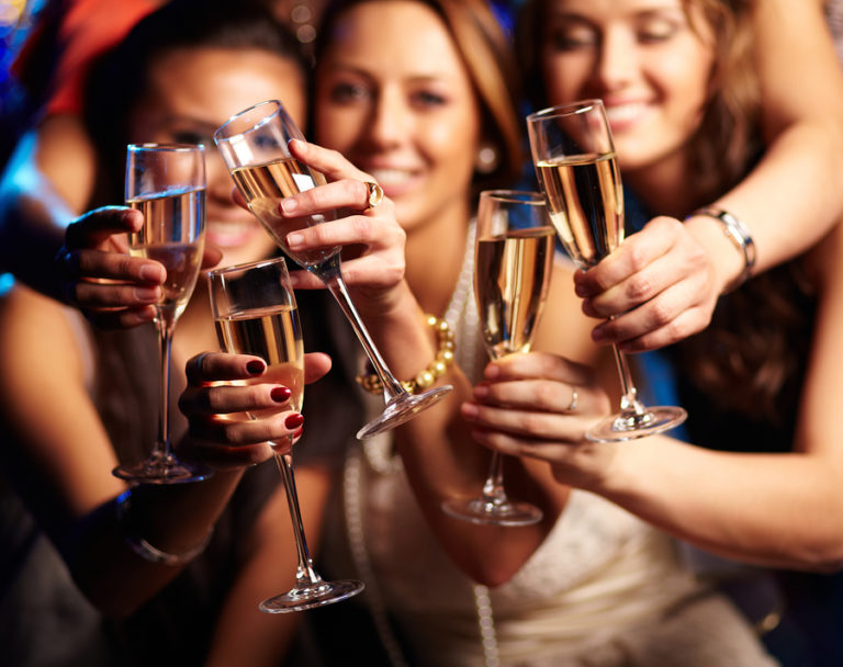 Groupe de filles faisant la fête trinquent avec des flûtes de vin mousseux